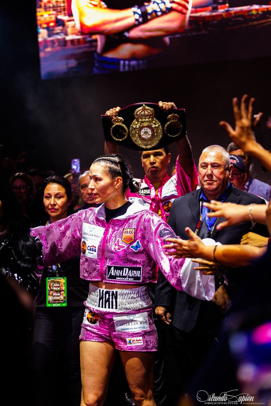 Boxer walking out with her team and the championship belt